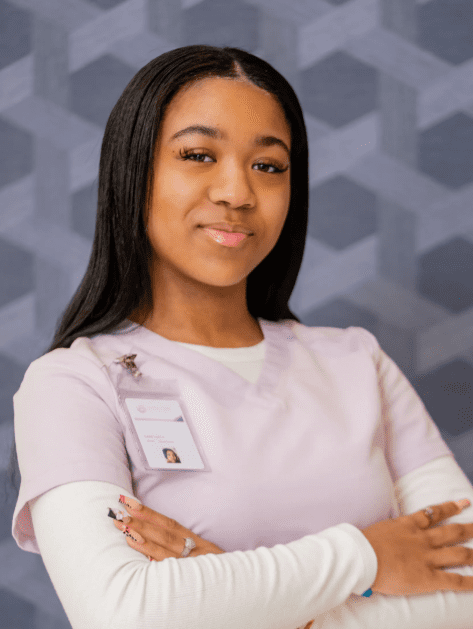 Person in scrubs with folded arms.