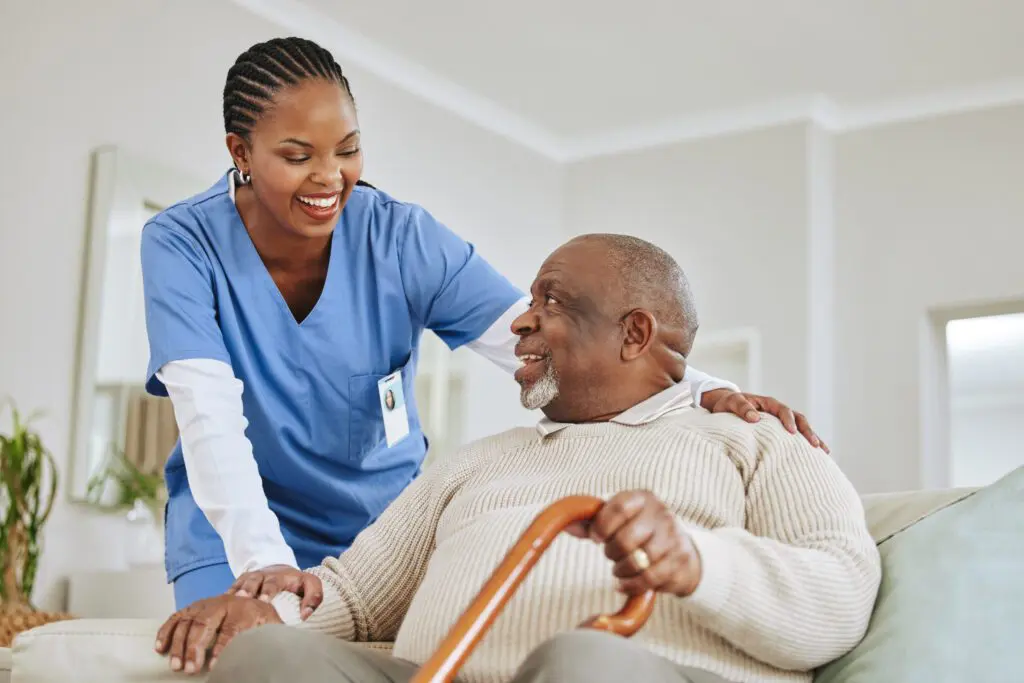 Nurse assisting elderly man with cane.