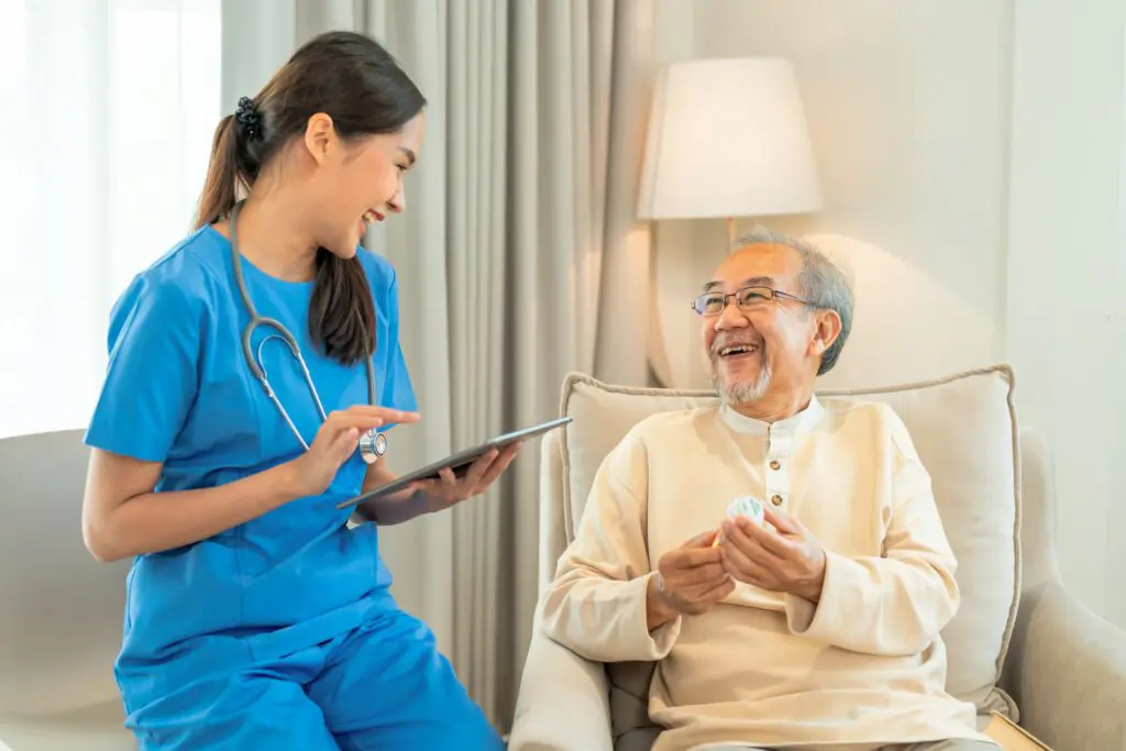 Nurse and elderly man smiling together.