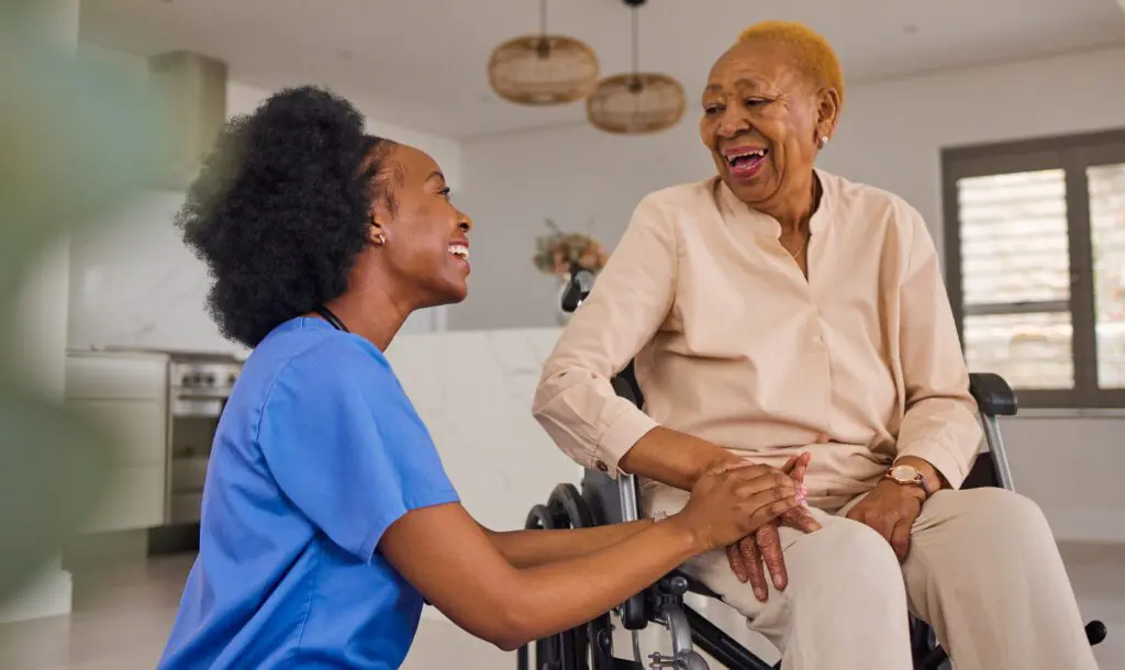 Caregiver smiling with woman in wheelchair.