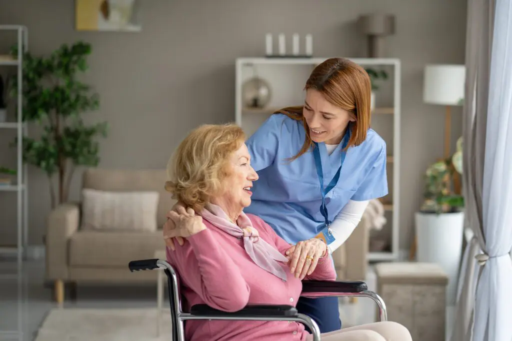Home nurse assisting seated older woman